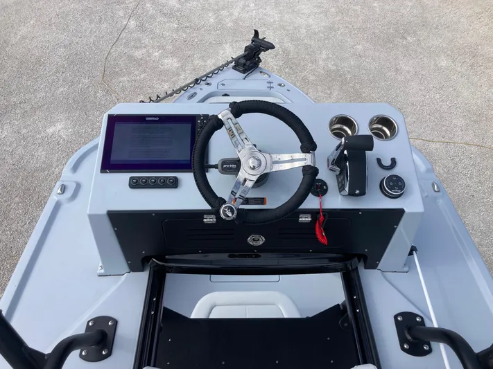  Yacht Photos Pics 2025 Crevalle 26HCO boat helm with steering wheel, controls, and display screen.