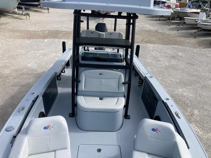  Yacht Photos Pics 2025 Crevalle 26HCO boat interior with seating and console, parked on gravel.