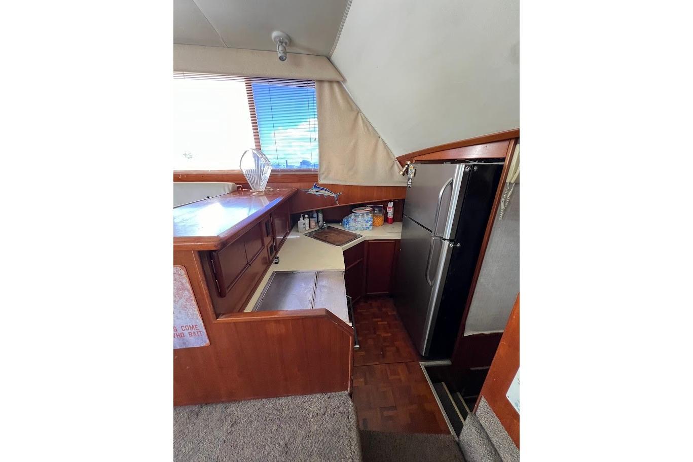 1988 Post 46 ll yacht interior kitchen with wood cabinetry and modern appliances.