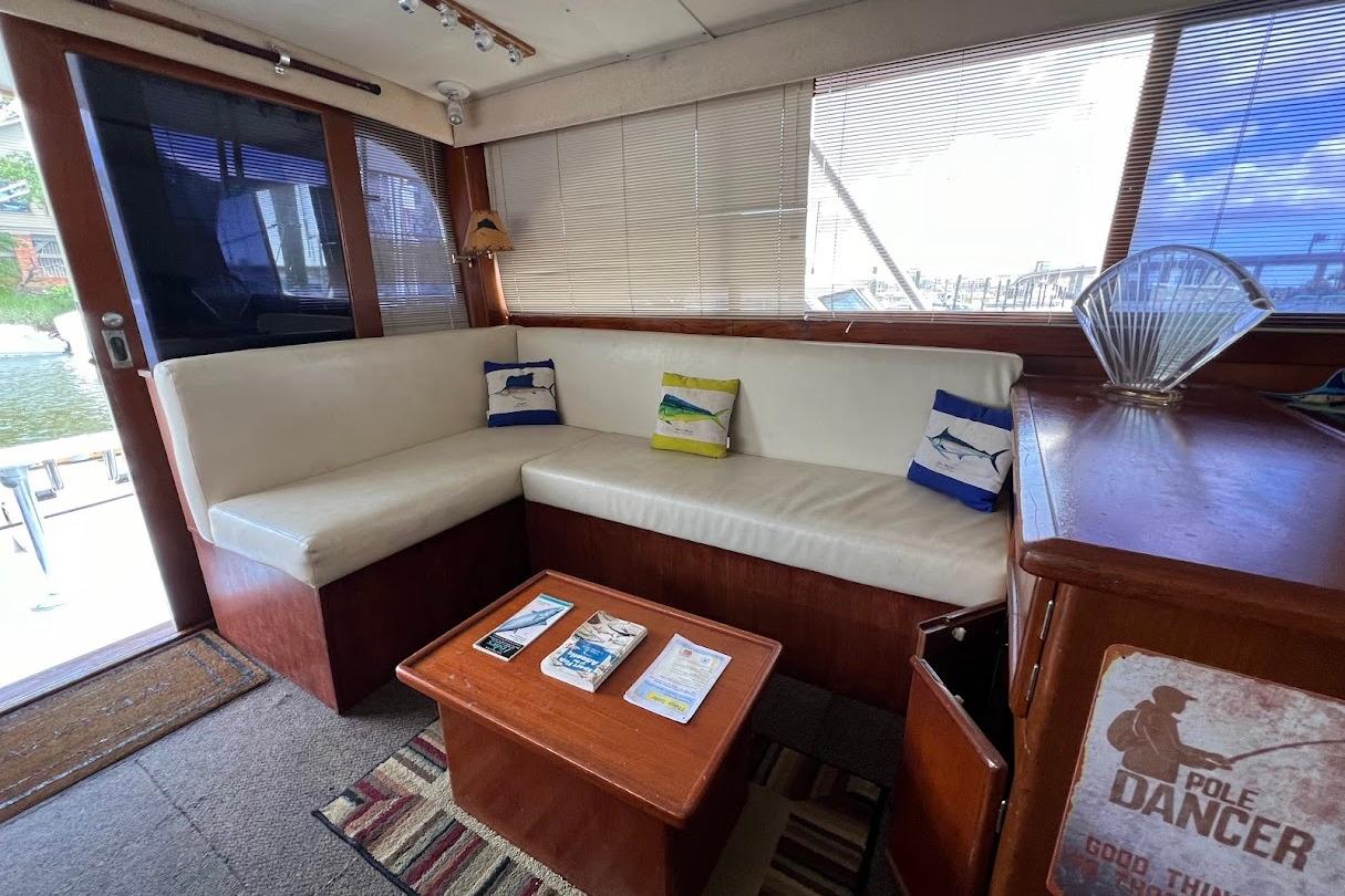 Cozy interior of 1988 Post 46 ll yacht with white seating and nautical decor.