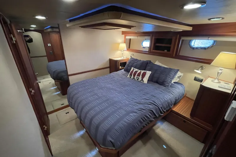 Pacific Rose Yacht Photos Pics Luxurious bedroom in 2009 American Tug 49 Limited yacht with cozy bedding and elegant lighting.