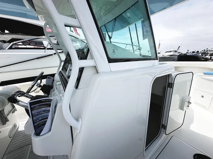Triple J Yacht Photos Pics 2018 HCB 39 Speciale boat cockpit with open cabin door and steering wheel.