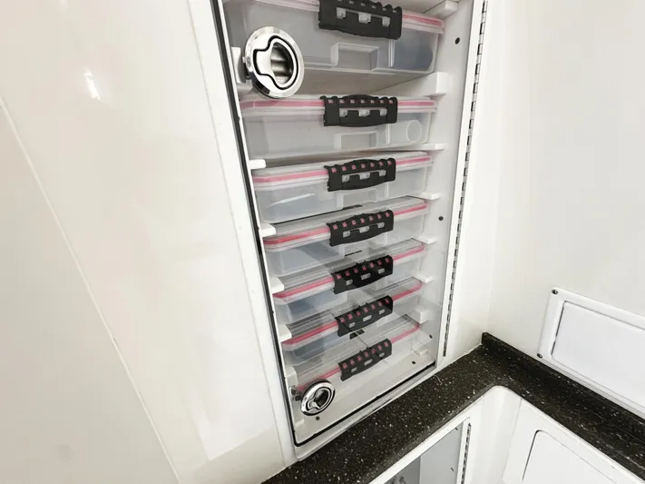 Triple J Yacht Photos Pics Storage compartments in a 2018 HCB 39 Speciale boat, featuring organized tackle boxes.
