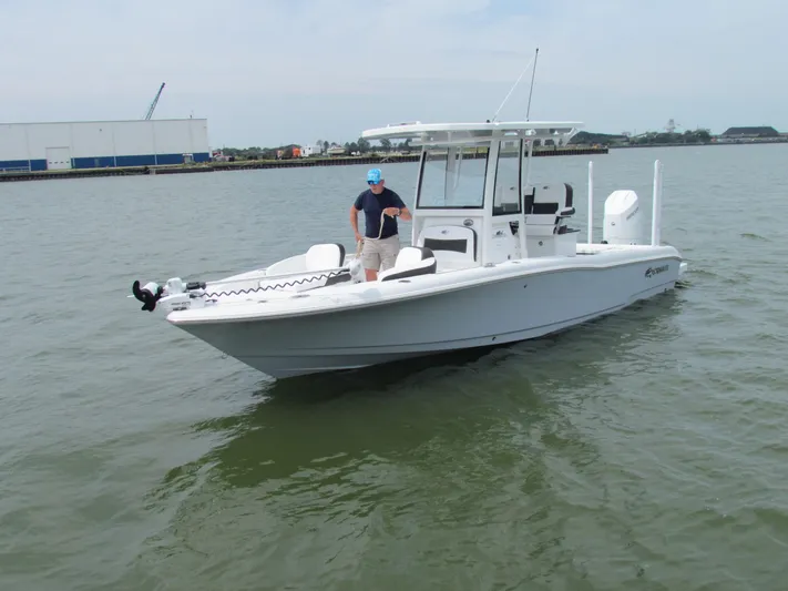 Model Year Clearance Yacht Photos Pics 2024 Crevalle 26 HCO boat on water with person standing at helm.