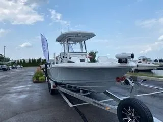 Model Year Clearance Yacht Photos Pics 2024 Crevalle 26 HCO boat on trailer in parking lot, under cloudy sky.