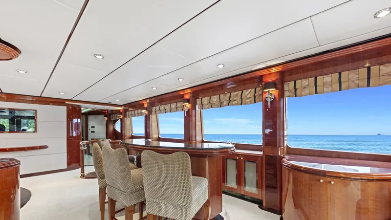 Destiny Yacht Photos Pics Luxurious yacht interior with ocean view, featuring elegant wood finishes and comfortable seating. Destiny 98', 2001.