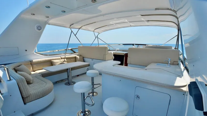 Destiny Yacht Photos Pics Luxurious yacht deck with seating and bar, Destiny 98', 2001 model, on open sea.