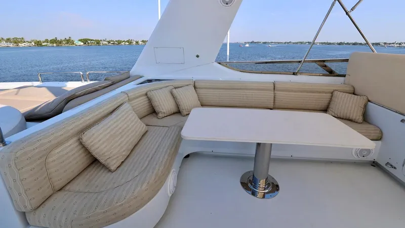 Destiny Yacht Photos Pics Luxurious yacht seating area with cushions and table, overlooking serene water view. Destiny 98', 2001.