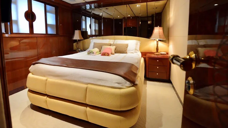 Destiny Yacht Photos Pics Luxurious bedroom interior on Destiny 98' yacht, 2001 model, featuring elegant decor and cozy lighting.