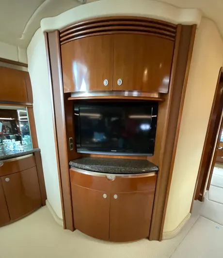 Decompressing Yacht Photos Pics Luxurious interior of 2005 Sea Ray 500 Sundancer with built-in TV and wooden cabinetry.