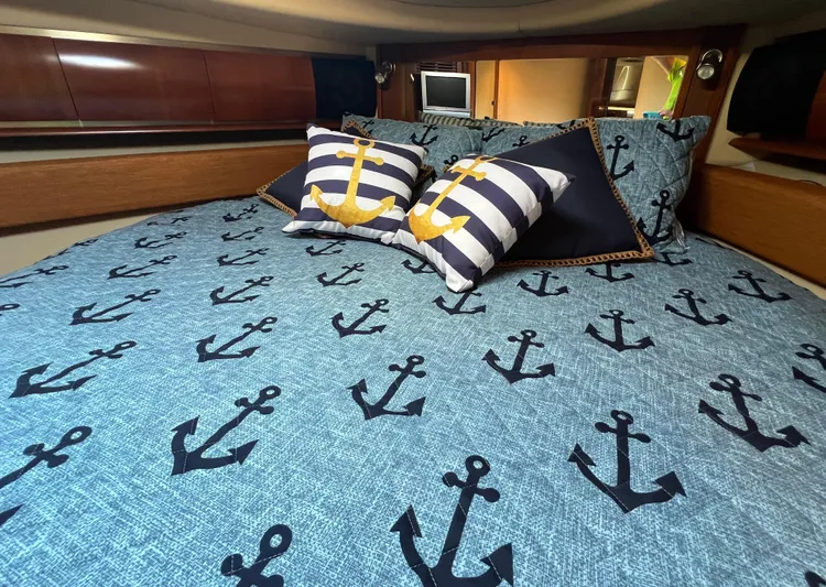 Decompressing Yacht Photos Pics Nautical-themed bedroom in 2005 Sea Ray 500 Sundancer yacht with anchor-patterned bedding.