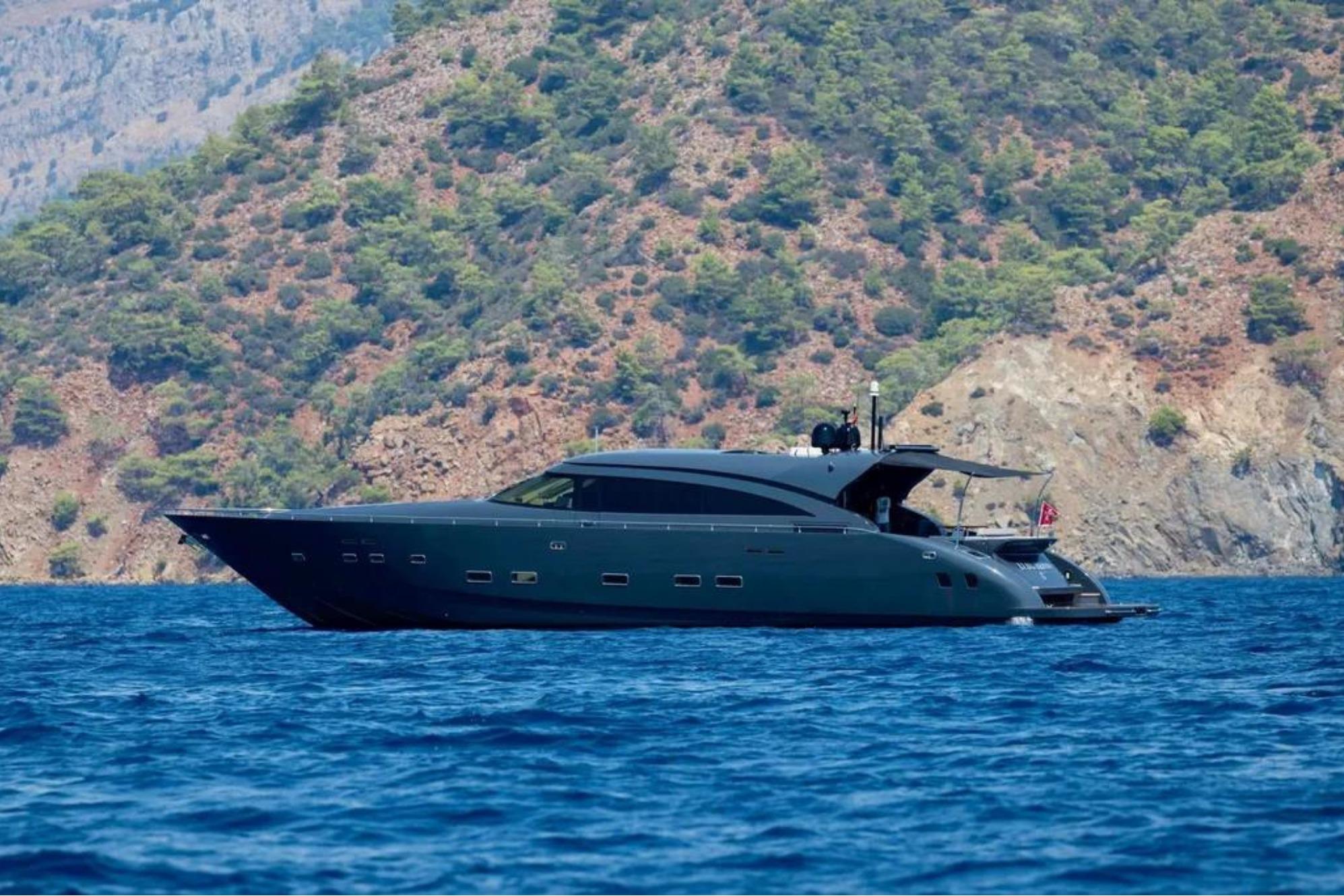 Luxurious 2006 AB 92 yacht cruising near scenic rocky coastline.