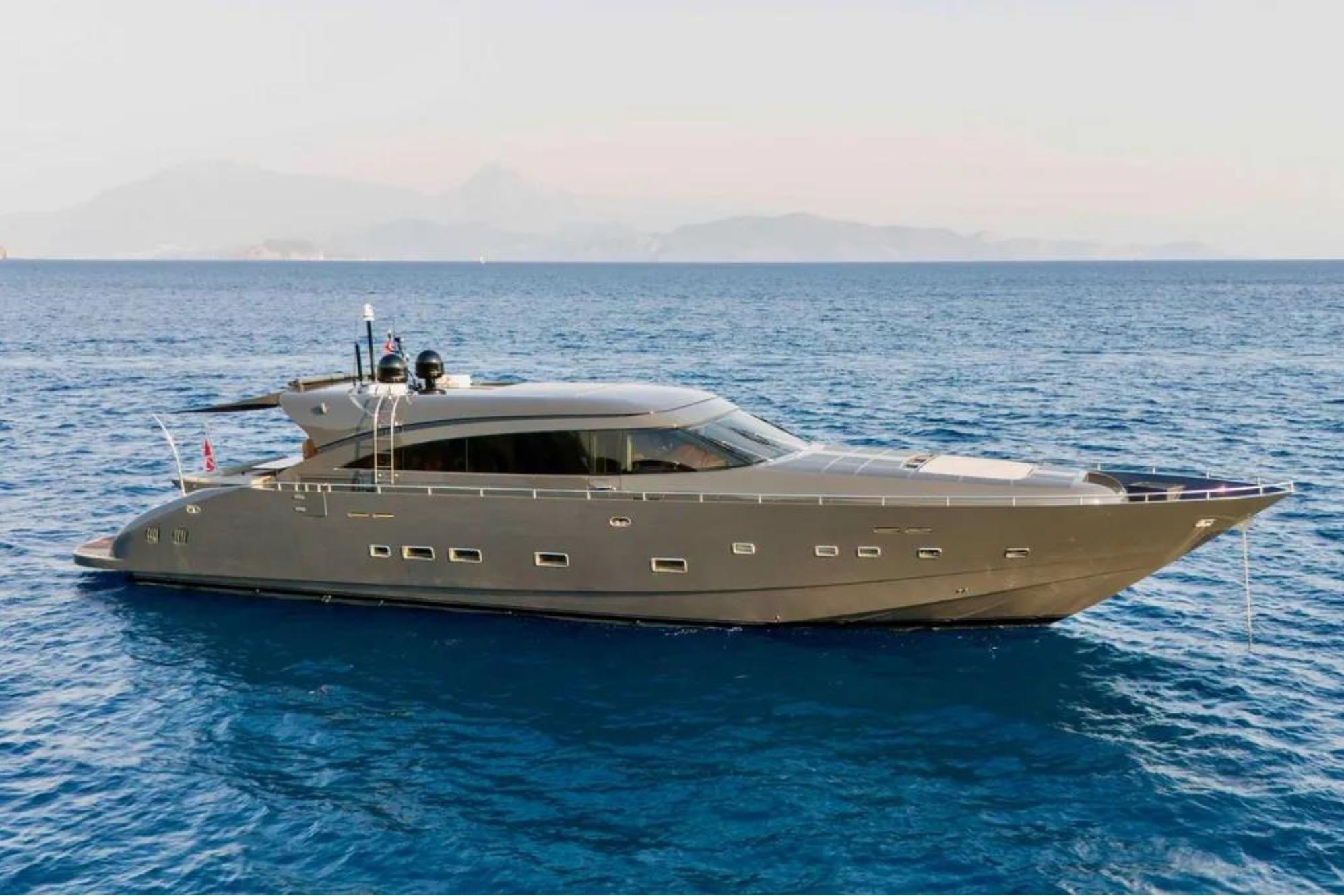 Luxury yacht AB 92, 2006 model, cruising on open sea with scenic mountain backdrop.