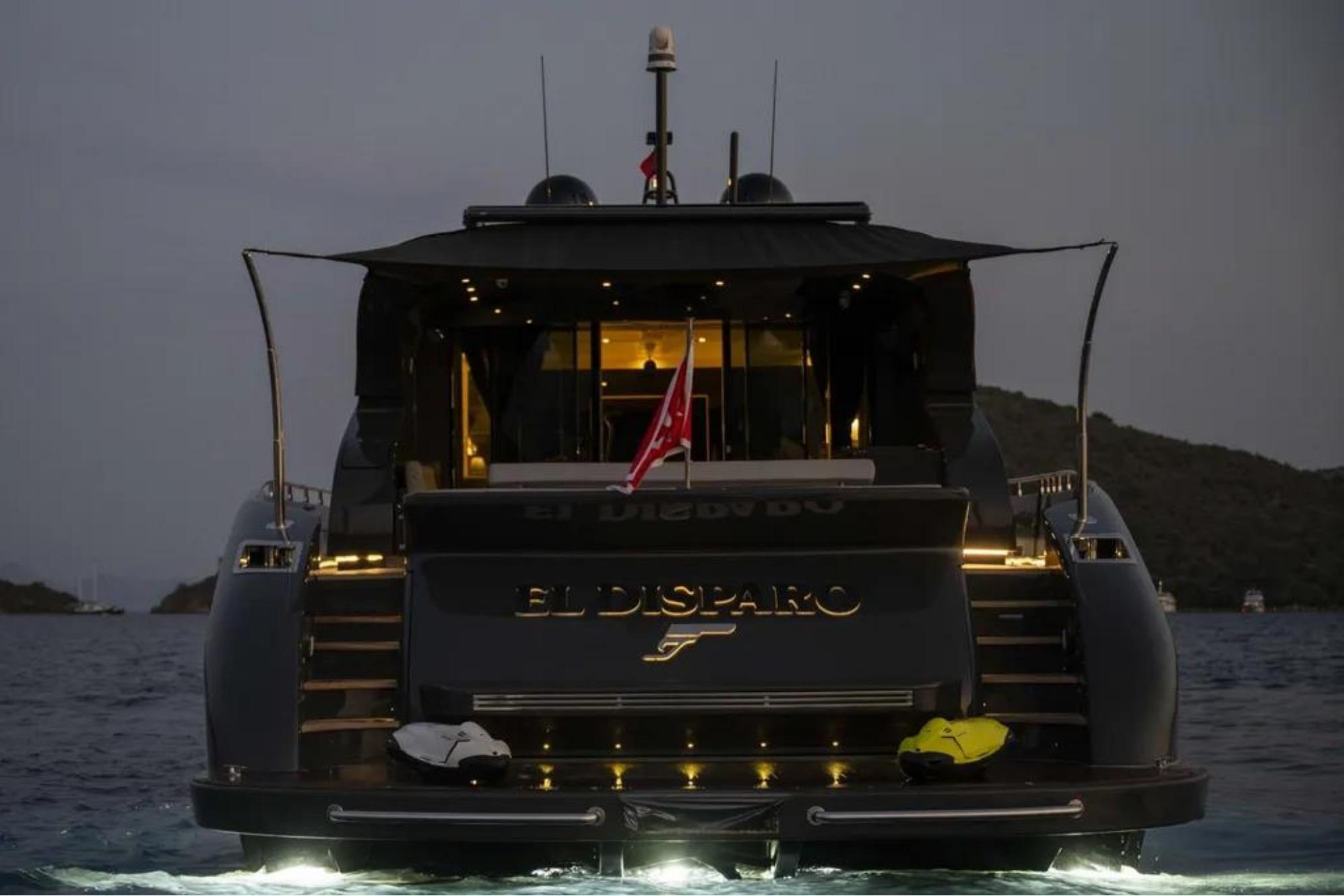 Luxurious 2006 AB 92 yacht "El Disparo" illuminated at night on the water.