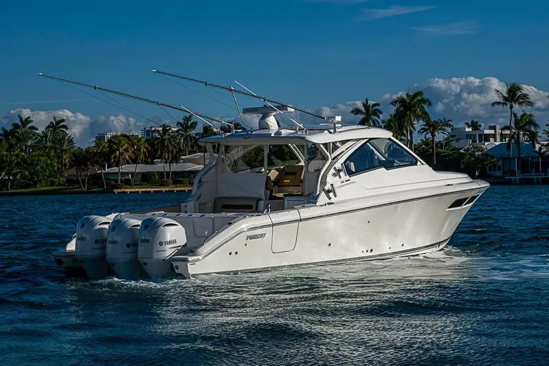  Yacht Photos Pics 2020 Pursuit DC 365 Dual Console boat cruising on a sunny day with palm trees in the background.