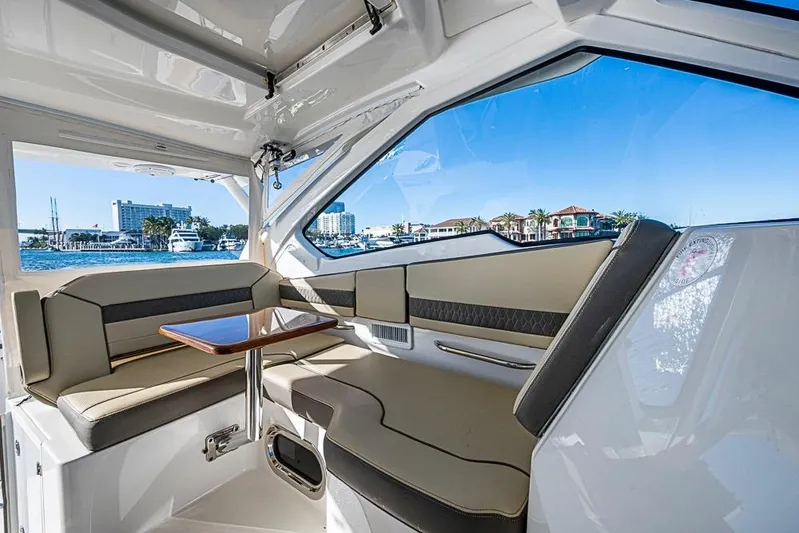  Yacht Photos Pics 2020 Pursuit DC 365 Dual Console interior with waterfront view, featuring comfortable seating and table.