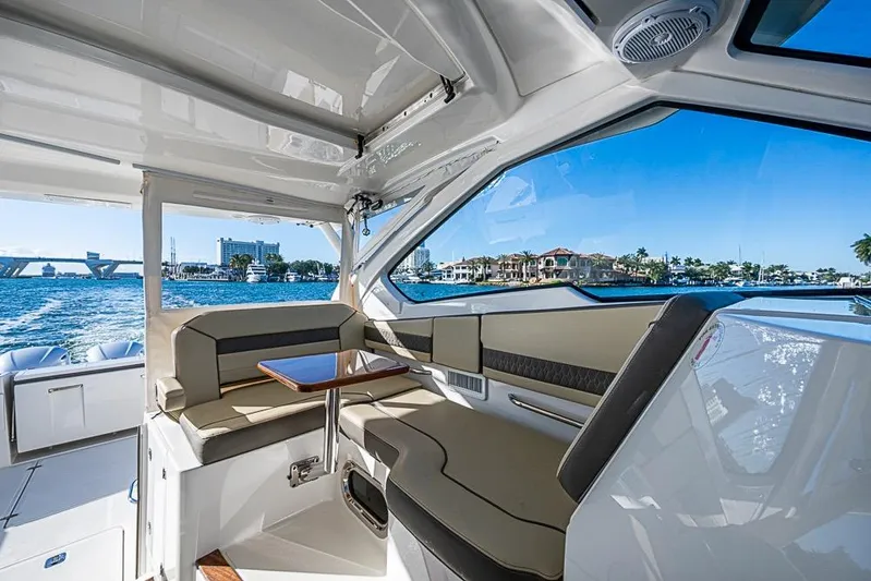  Yacht Photos Pics 2020 Pursuit DC 365 Dual Console interior with waterfront view, featuring comfortable seating and table.