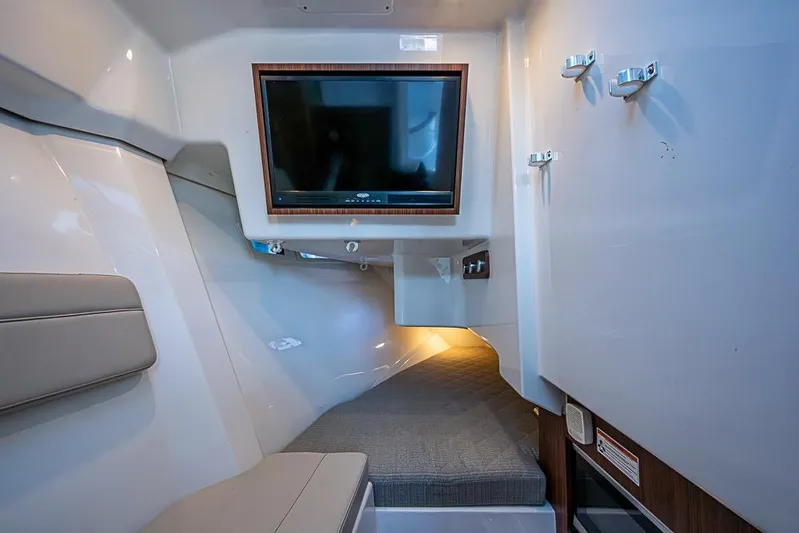  Yacht Photos Pics 2020 Pursuit DC 365 Dual Console cabin interior with TV and seating area.