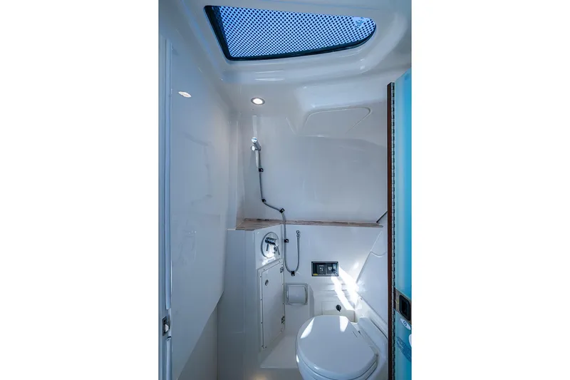  Yacht Photos Pics 2020 Pursuit DC 365 Dual Console boat bathroom interior with skylight and modern fixtures.