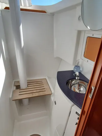 My Three Girls Yacht Photos Pics Compact bathroom in 2004 Lagoon 43 PC yacht with sink and wooden seat.