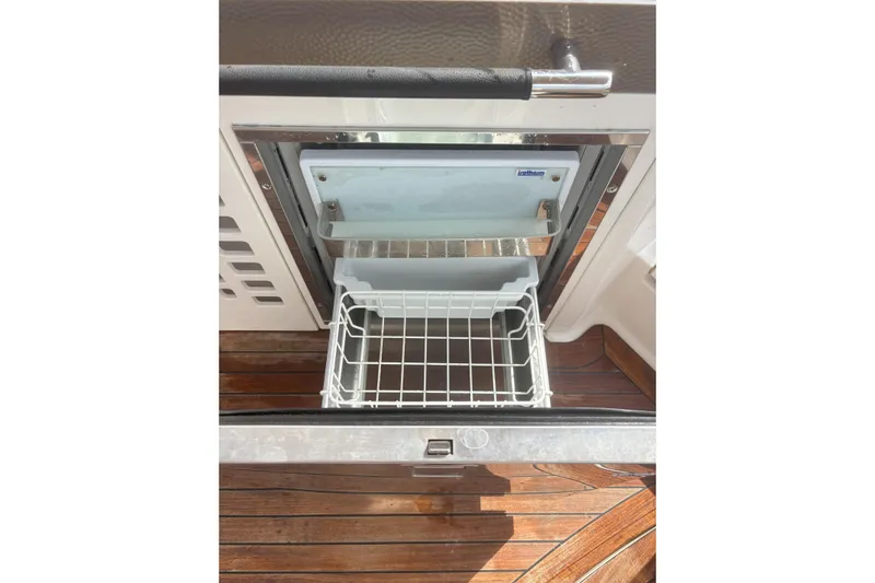  Yacht Photos Pics Open drawer refrigerator on 2016 Sea Ray 350 SLX boat, featuring wooden flooring.