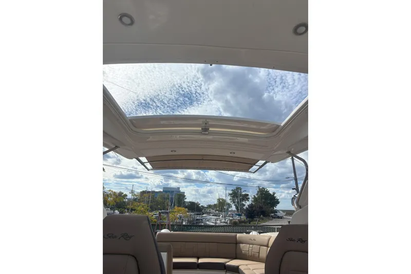  Yacht Photos Pics 2016 Sea Ray 350 SLX boat interior with open sunroof, showcasing sky and marina view.