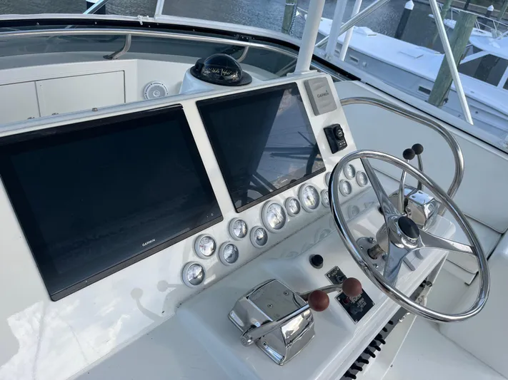 Amen Corner Yacht Photos Pics Control panel of a 1995 Hatteras 45 Convertible yacht with dual screens and steering wheel.