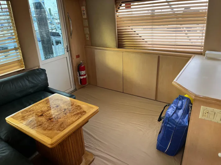 Amen Corner Yacht Photos Pics Interior of 1995 Hatteras 45 Convertible yacht with wooden table and leather seating.