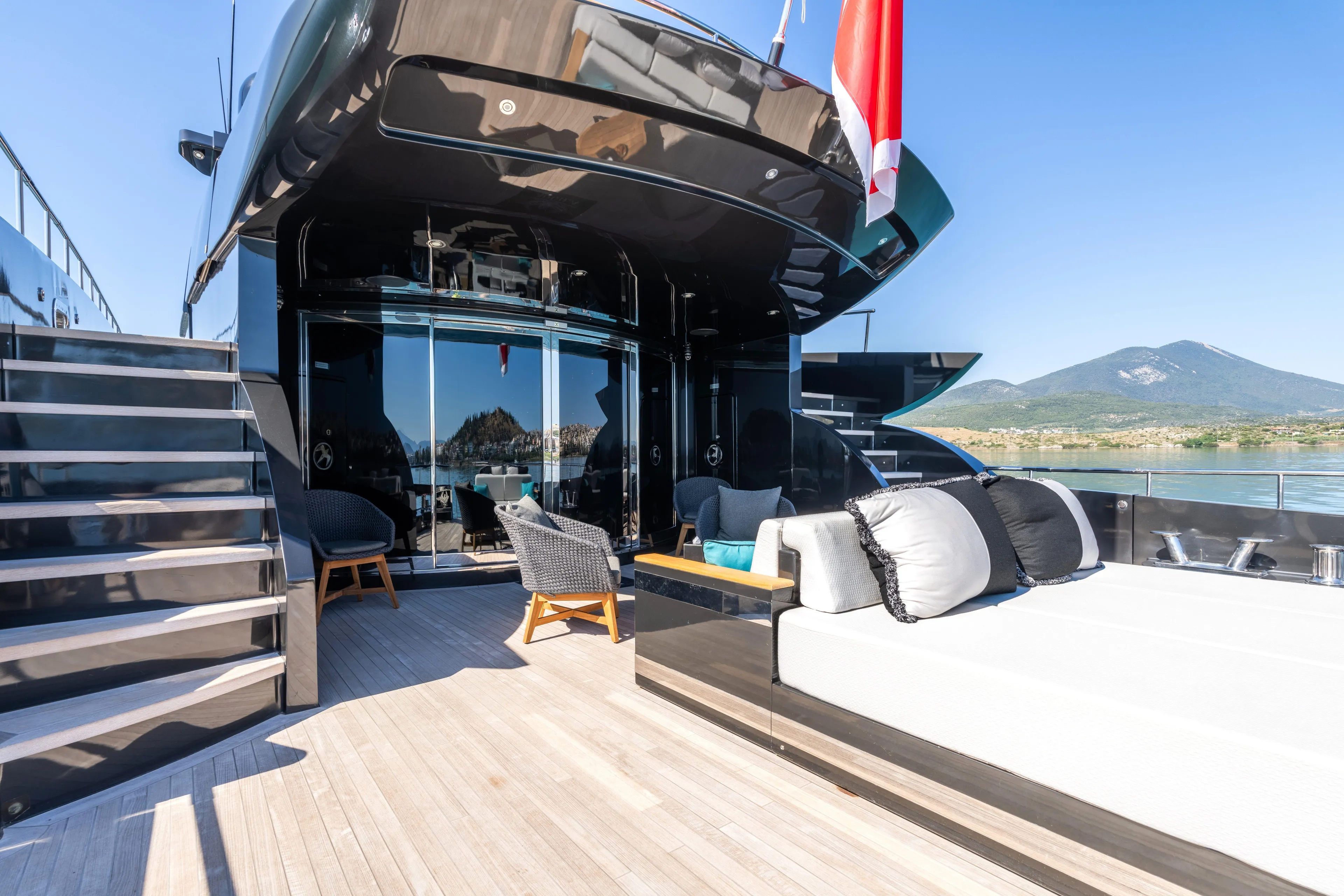 Aquila Yacht Photos Pics Luxurious 2004 Baglietto Custom yacht deck with modern seating and scenic mountain view.