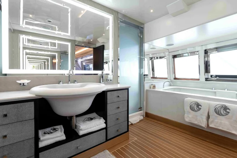 Aquila Yacht Photos Pics Luxurious yacht bathroom with modern fixtures, illuminated mirror, and elegant wood flooring, Baglietto Custom 2004.
