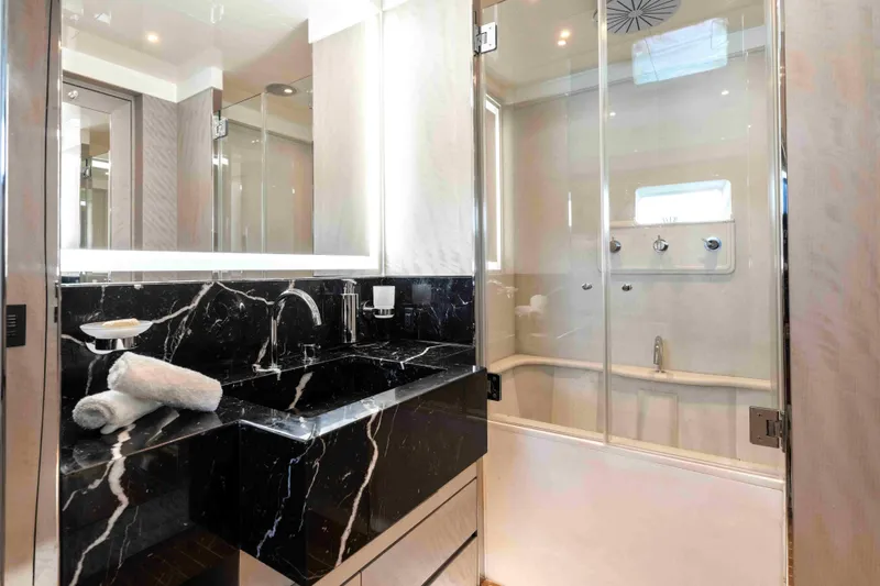 Aquila Yacht Photos Pics Luxurious yacht bathroom with black marble sink, glass shower, and modern fixtures, Baglietto Custom 2004.