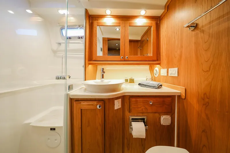  Yacht Photos Pics Luxurious bathroom interior of 2025 Sabre 45 Salon Express yacht, featuring wood cabinetry and modern fixtures.