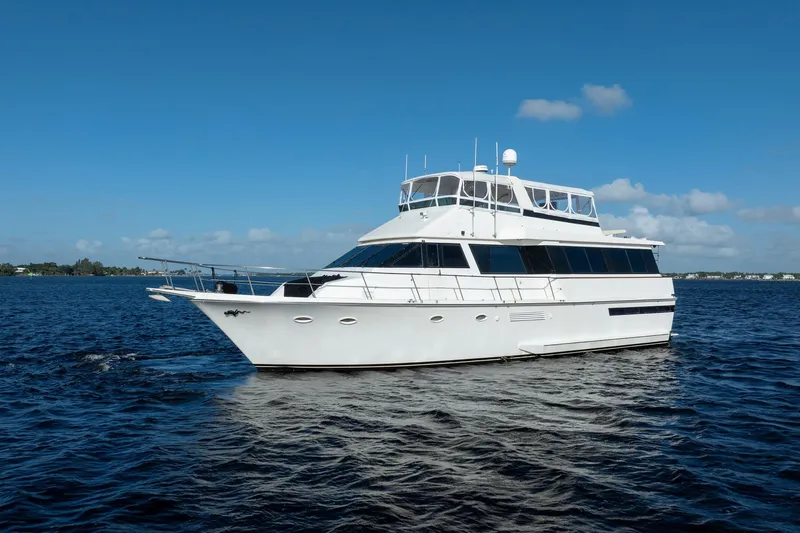 Jubilee Yacht Photos Pics 1989 Viking 63 Motor Yacht cruising on open water under clear blue skies.