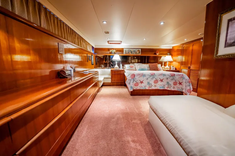 Jubilee Yacht Photos Pics Luxurious 1989 Viking 63 Motor Yacht bedroom with elegant wood paneling and cozy decor.