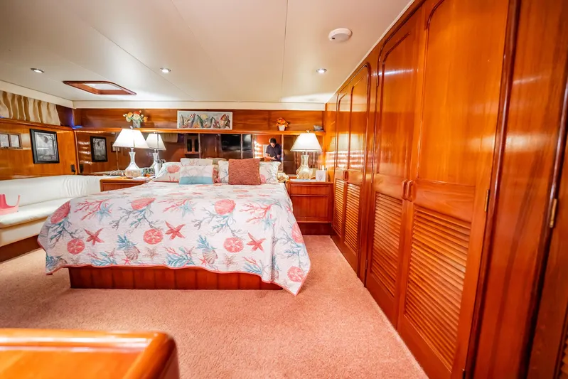 Jubilee Yacht Photos Pics Luxurious bedroom interior of 1989 Viking 63 Motor Yacht with wood paneling and cozy decor.