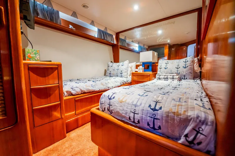 Jubilee Yacht Photos Pics Cozy cabin interior of 1989 Viking 63 Motor Yacht with nautical-themed bedding.