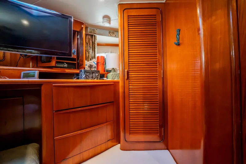 Jubilee Yacht Photos Pics Interior of 1989 Viking 63 Motor Yacht with wooden cabinetry and mounted TV.