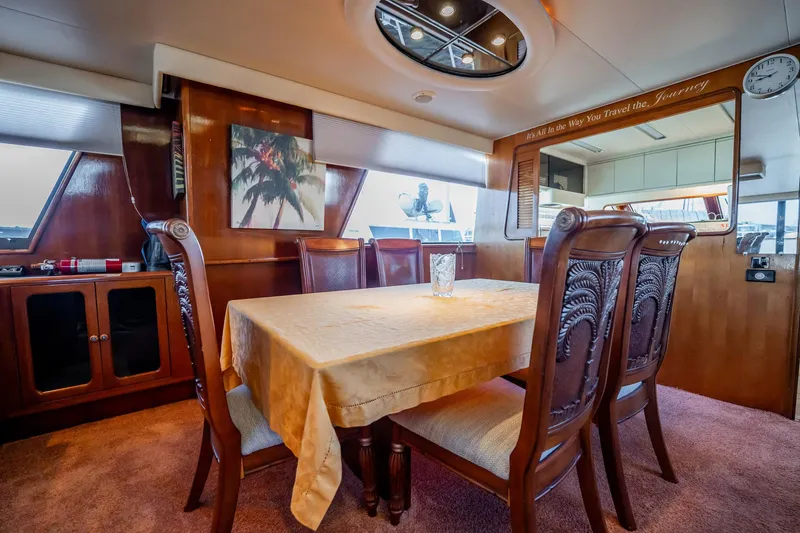 Jubilee Yacht Photos Pics Elegant dining area in 1989 Viking 63 Motor Yacht with wooden decor and plush seating.