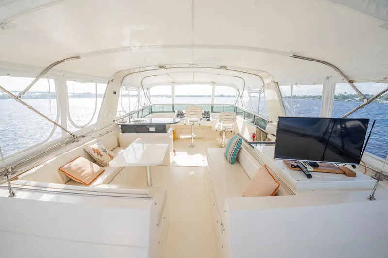 Jubilee Yacht Photos Pics Spacious interior of 1989 Viking 63 Motor Yacht with seating and TV, overlooking water.