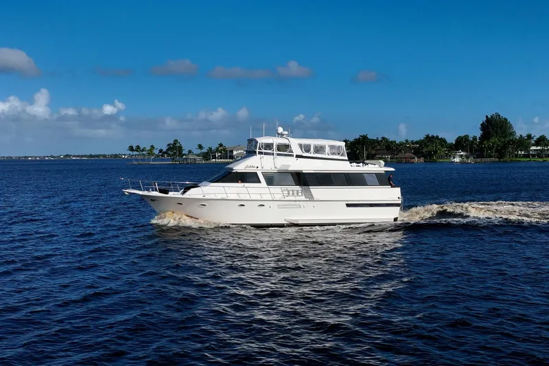 Jubilee Yacht Photos Pics 1989 Viking 63 Motor Yacht cruising on a sunny day, surrounded by blue water.
