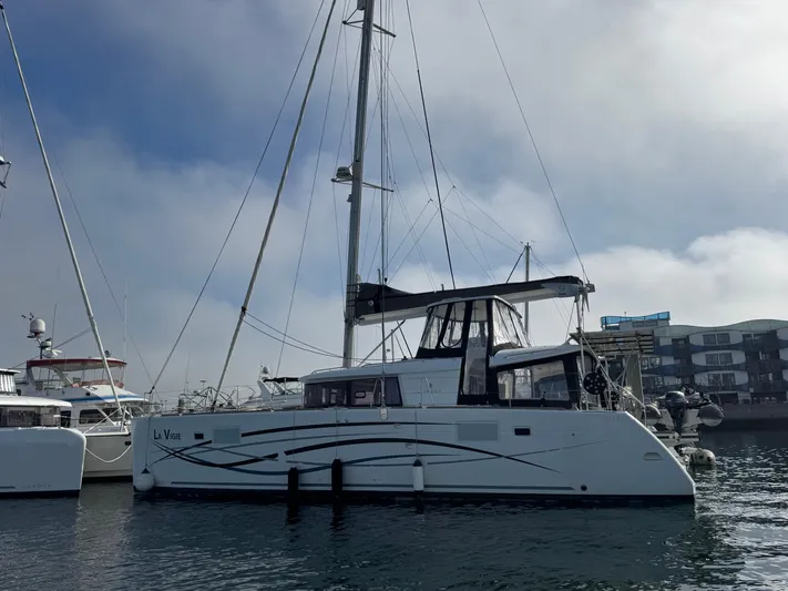 La Vigie Yacht Photos Pics 2018 Lagoon 450 F catamaran docked in a marina under a cloudy sky.