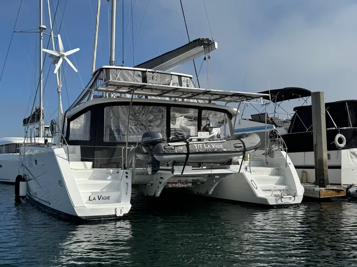 La Vigie Yacht Photos Pics 2018 Lagoon 450 F catamaran docked at marina with dinghy and wind turbine.
