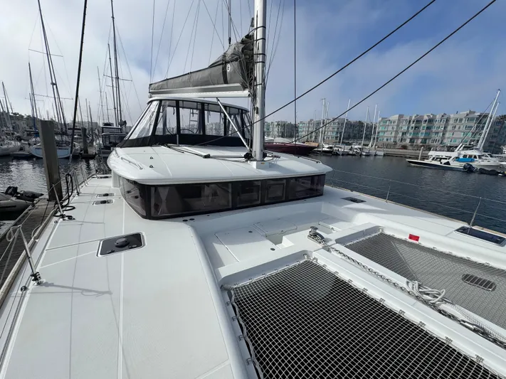La Vigie Yacht Photos Pics 2018 Lagoon 450 F catamaran docked at a marina, showcasing spacious deck and netting.