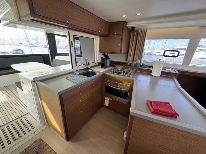 La Vigie Yacht Photos Pics Modern kitchen interior of 2018 Lagoon 450 F catamaran with wood cabinetry and appliances.