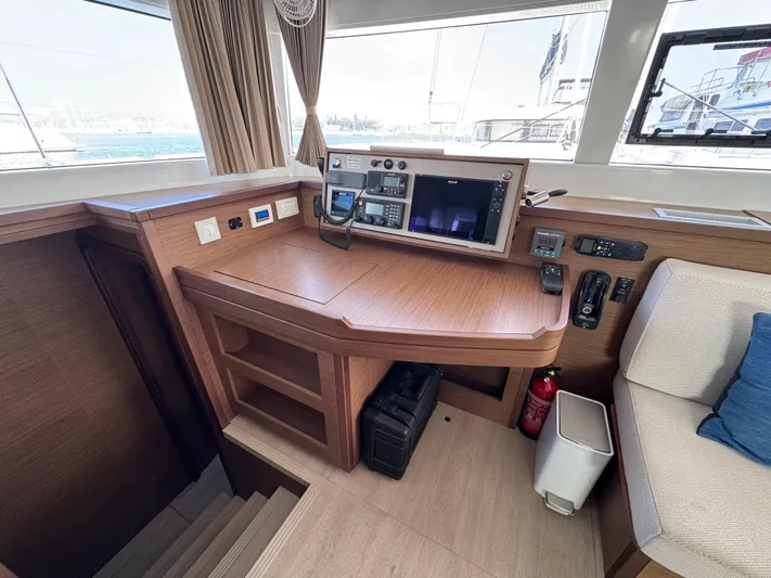 La Vigie Yacht Photos Pics Interior helm station of 2018 Lagoon 450 F catamaran with navigation equipment and wooden finish.