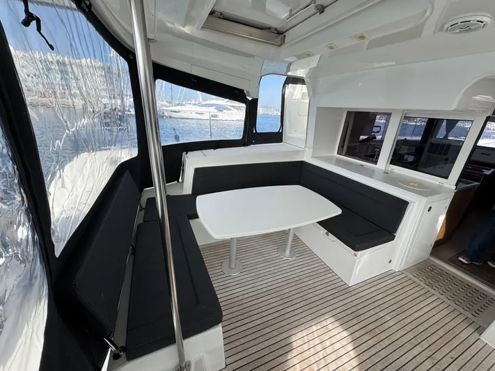 La Vigie Yacht Photos Pics Interior of 2018 Lagoon 450 F catamaran with seating and table, docked at marina.