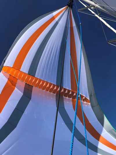 La Vigie Yacht Photos Pics Colorful sail of a 2018 Lagoon 450 F catamaran against a clear blue sky.