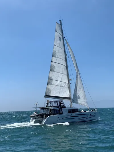 La Vigie Yacht Photos Pics 2018 Lagoon 450 F sailing catamaran on open sea under clear blue sky.