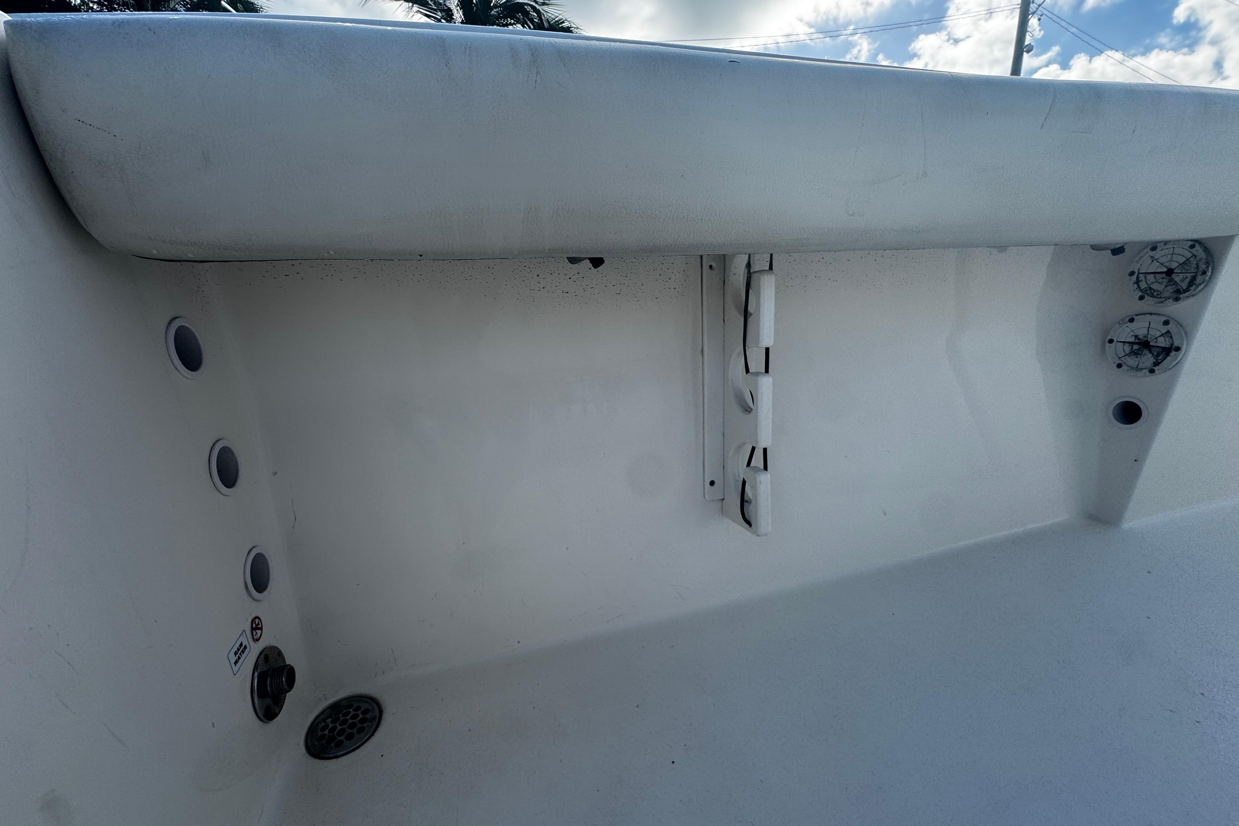 2021 Cobia 220 Center Console boat interior with rod holders and drainage system.