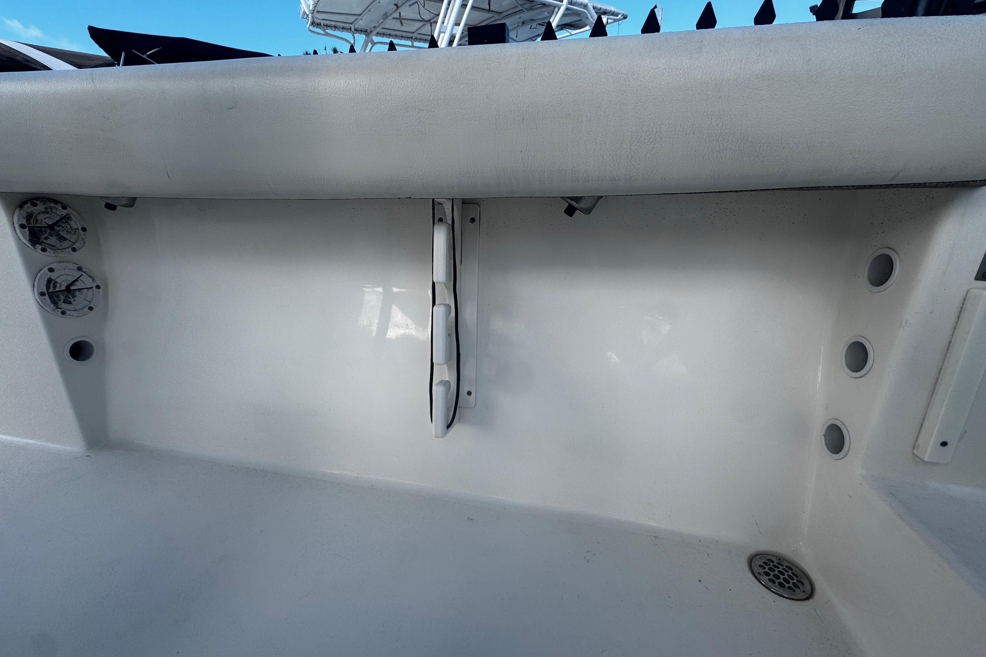 2021 Cobia 220 Center Console boat interior, featuring rod holders and drainage system.